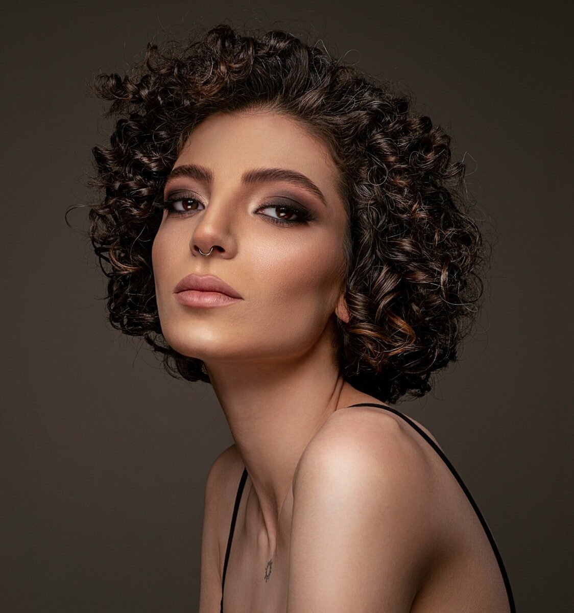 a woman with curly hair wearing a black dress