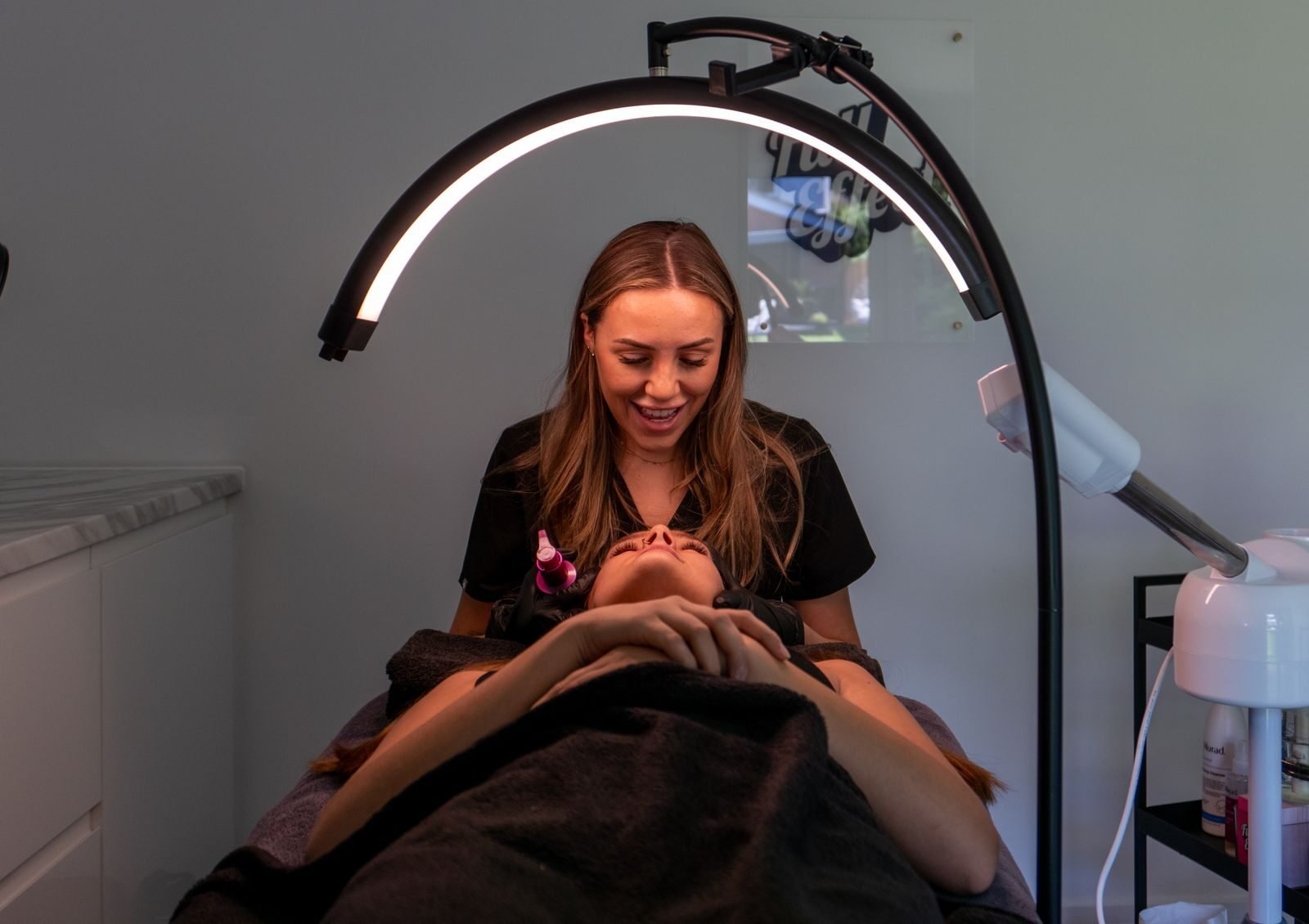 Beautician giving a facial treatment in a modern spa. Relaxing atmosphere and professional care.